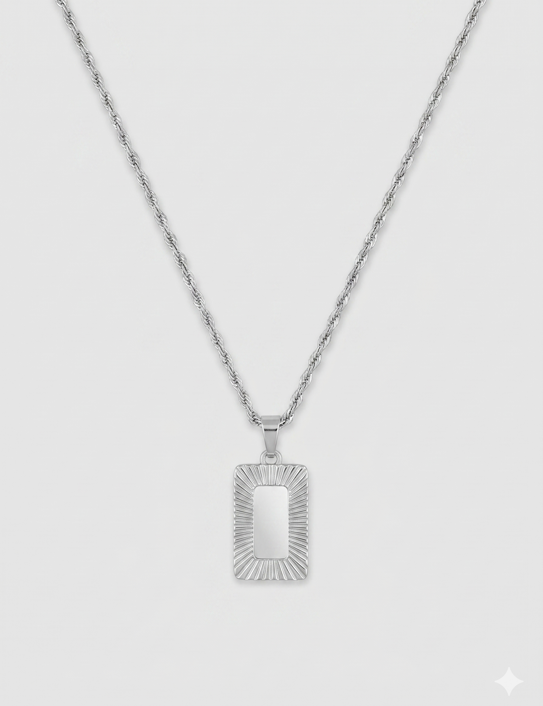שרשרת גברים בגוון כסף מבריק מסוג חבל שזור (Rope chain) עם תליון מלבני ארכיטקטוני. מרכז התליון חלק ומסגרתו מעוטרת בחריצי עומק רדיאליים המדמים קרני שמש.