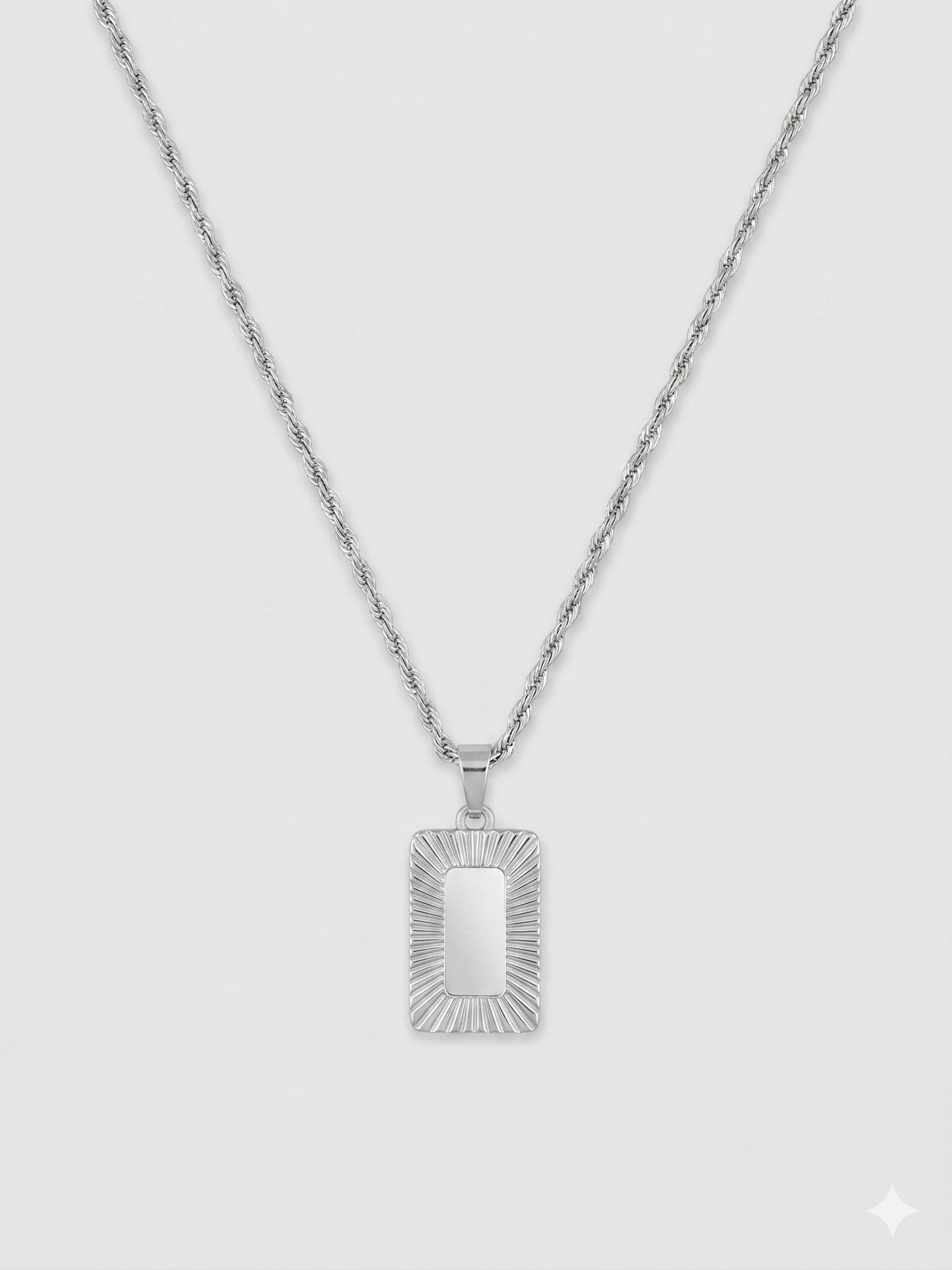 שרשרת גברים בגוון כסף מבריק מסוג חבל שזור (Rope chain) עם תליון מלבני ארכיטקטוני. מרכז התליון חלק ומסגרתו מעוטרת בחריצי עומק רדיאליים המדמים קרני שמש.