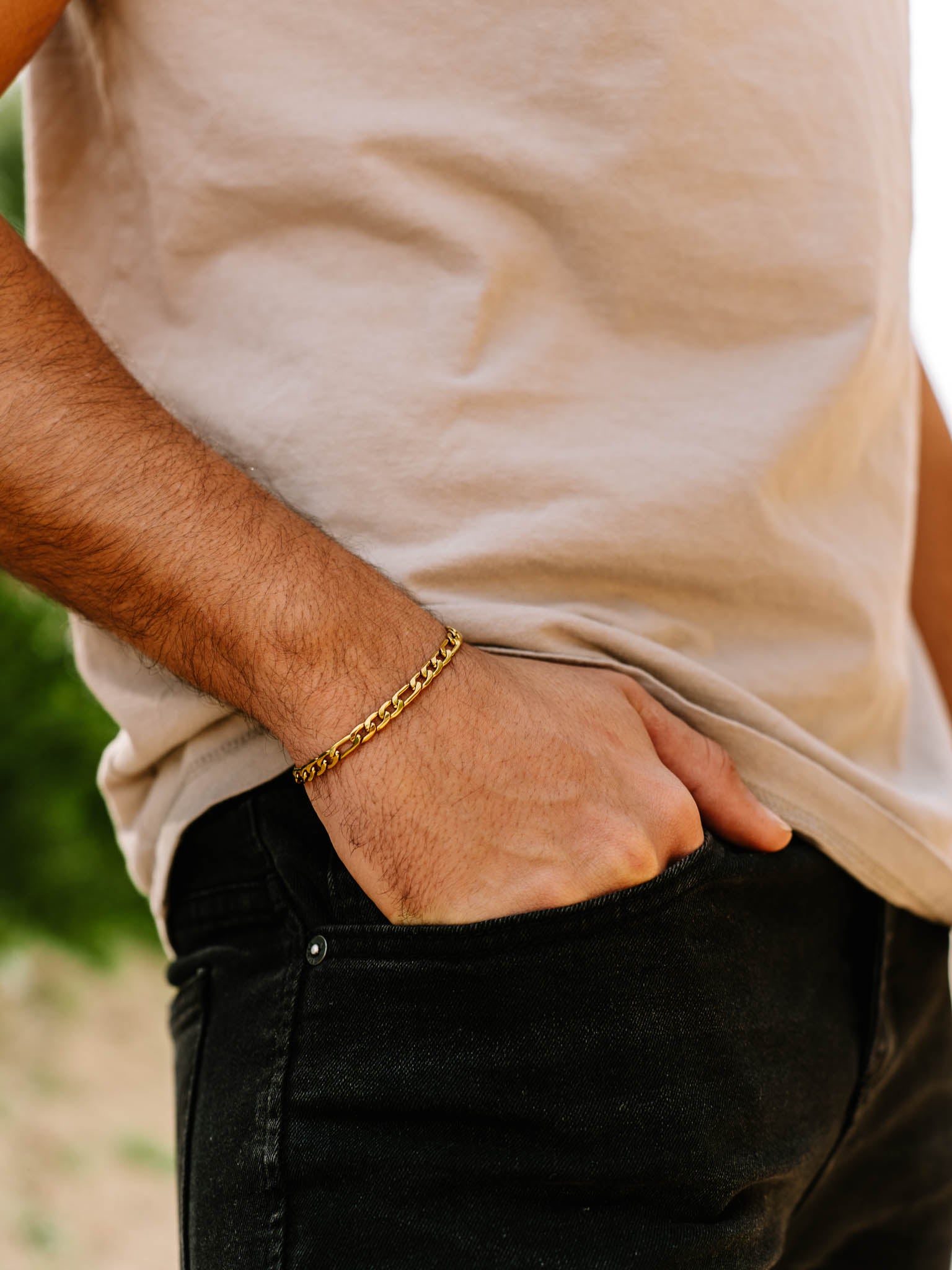 צמיד Apollo של NERO זהב על יד של גבר עם יד בכיס