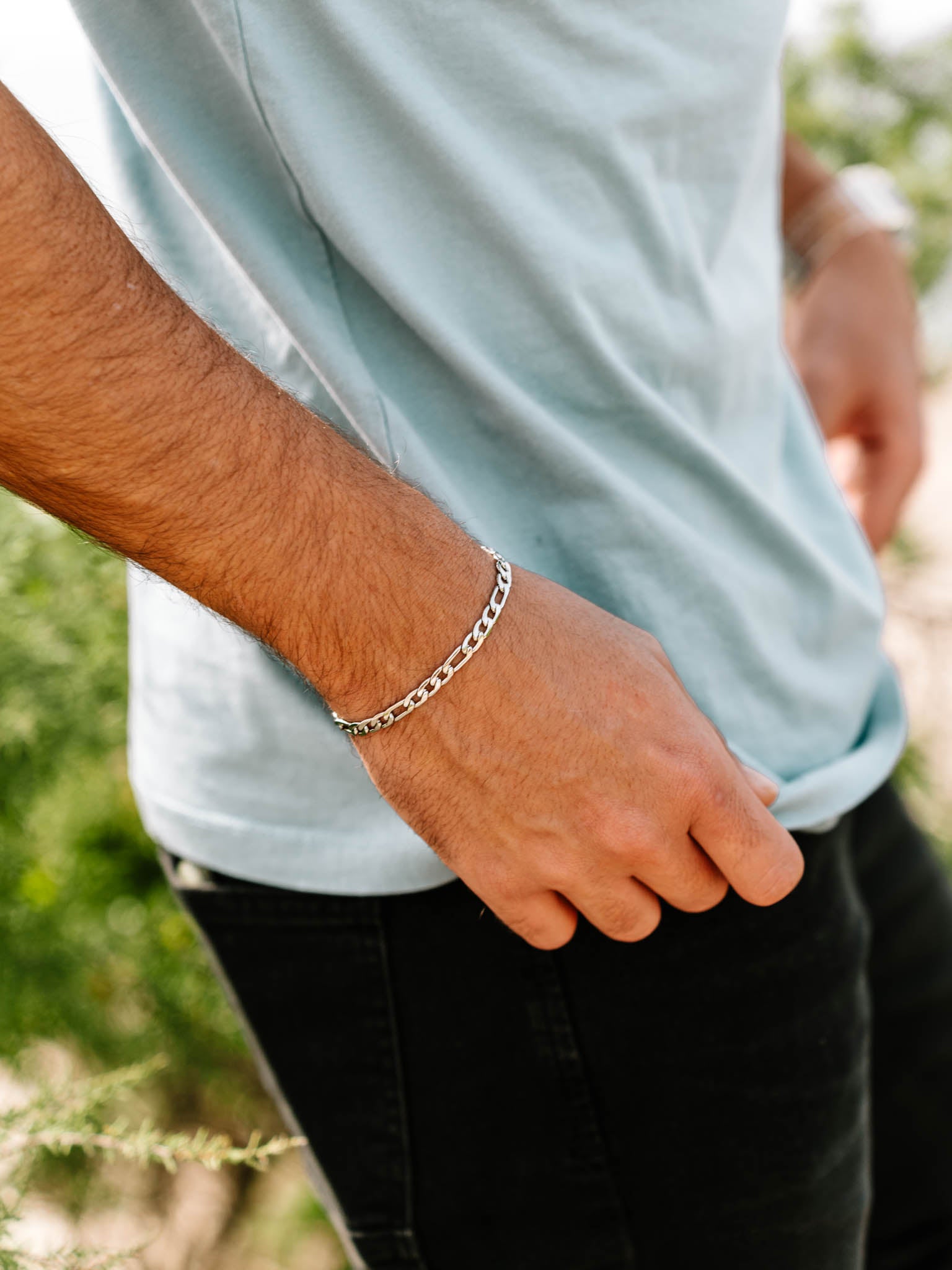 צמיד Apollo של NERO כסף על פרק היד עם חולצה תכלת בצילום חוץ