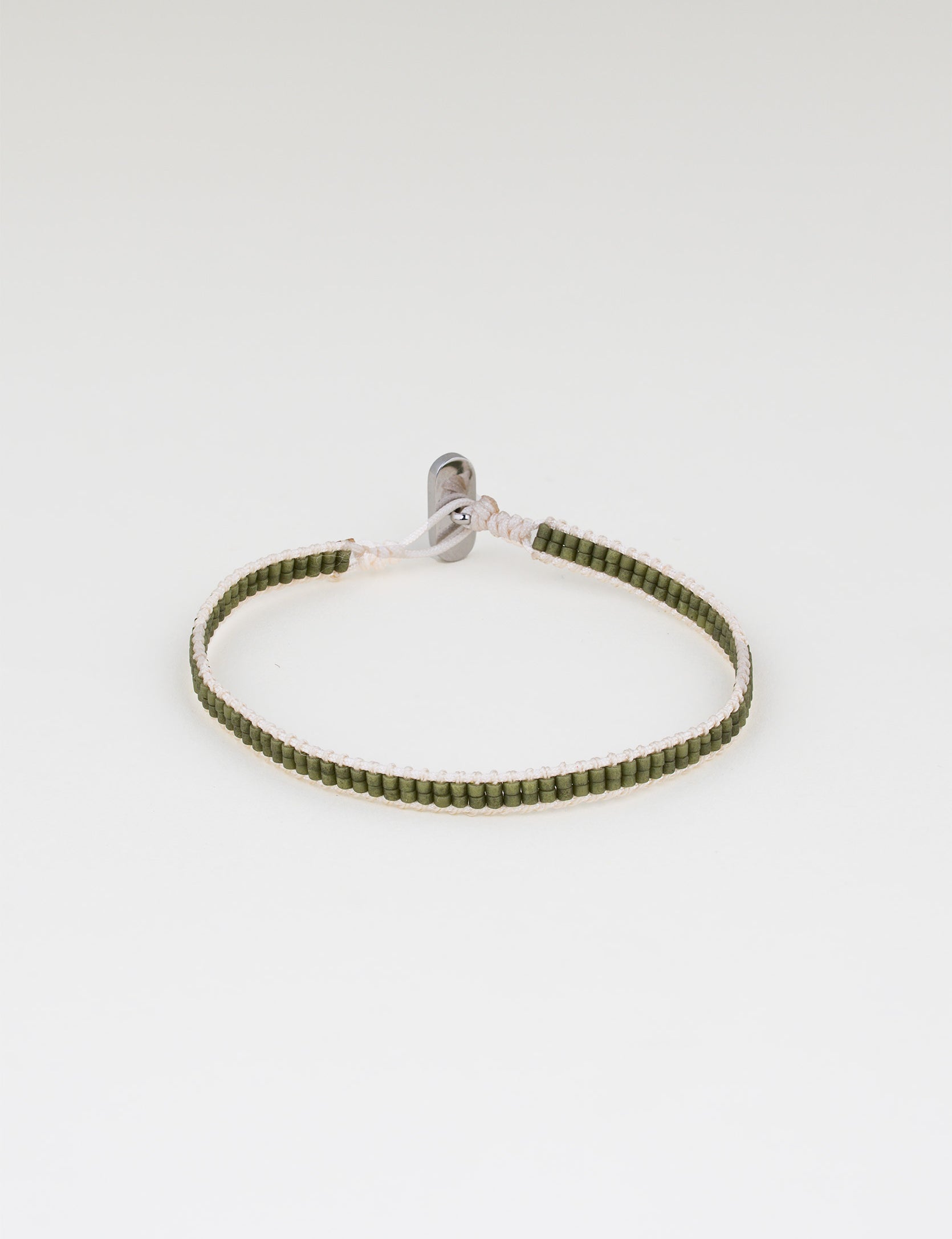 צמיד Aqua ירוק זית עדין, סרוג מחוט בהיר וחרוזים ירוקים קטנים, על רקע לבן.