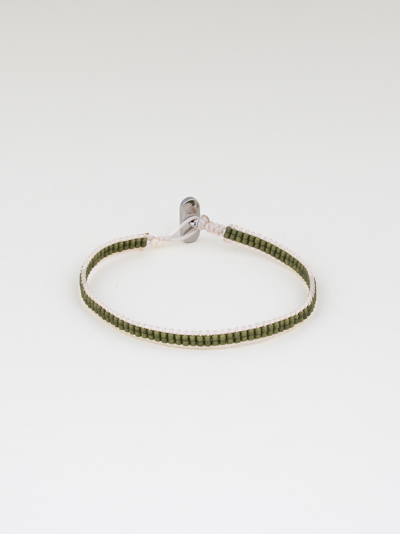 צמיד Aqua ירוק זית עדין, סרוג מחוט בהיר וחרוזים ירוקים קטנים, על רקע לבן.
