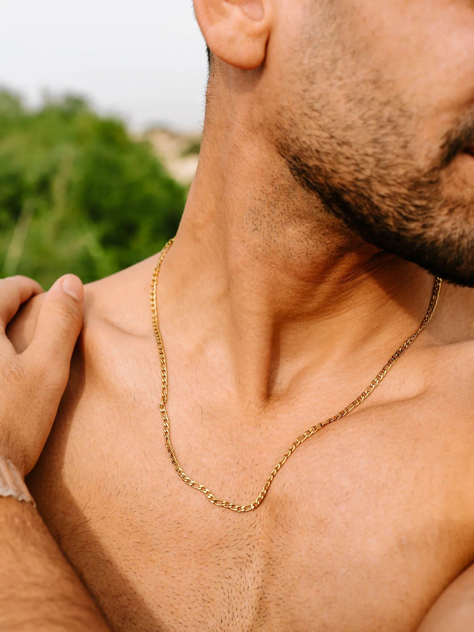 שרשרת Aura זהב על צוואר של דוגמן בצילום קלוז־אפ outdoors