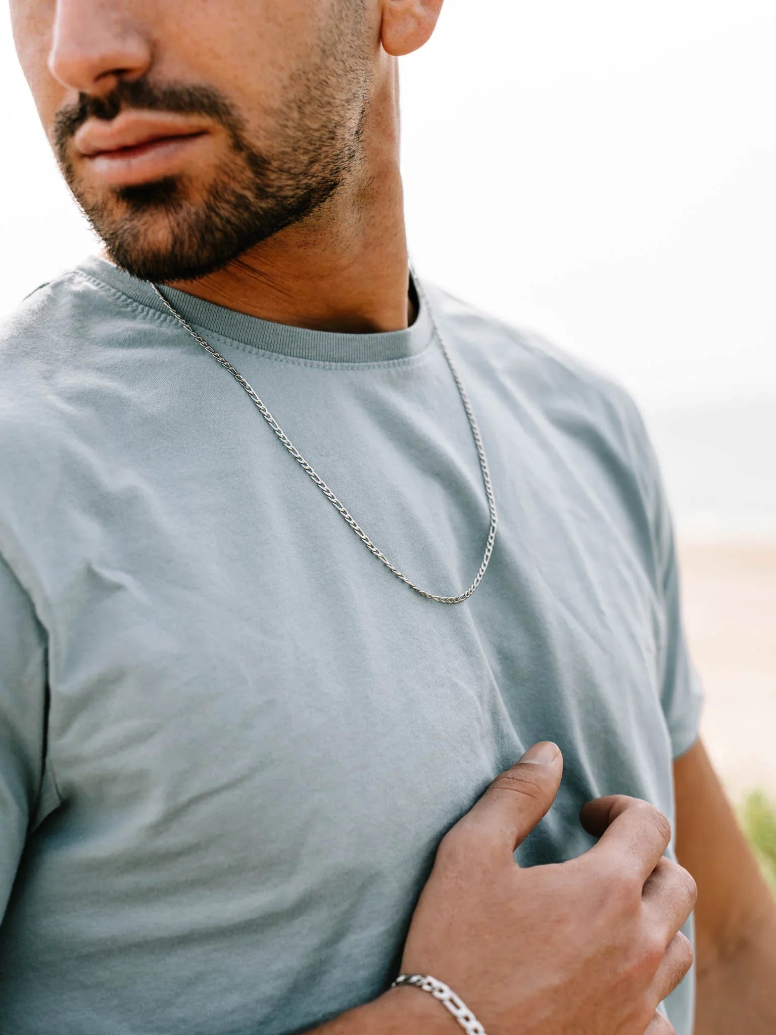 שרשרת כסף לגבר מדגם Aura מצולמת על גוף גבר בחוף, סטייל יומיומי ונקי