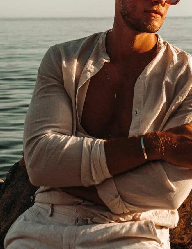 לייף סטייל – גבר ליד הים עם שרשרת Barracuda של NERO בצבע כסף, סטייל מינימליסטי קיצי.