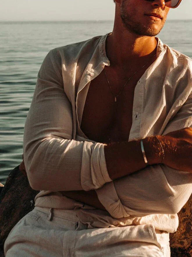 לייף סטייל – גבר ליד הים עם שרשרת Barracuda של NERO בצבע כסף, סטייל מינימליסטי קיצי.