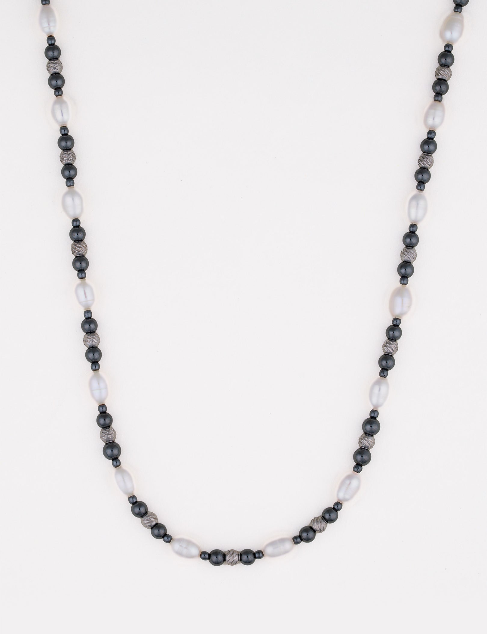 שרשרת Caviar מפנינים לבנות ארוכות וחרוזי המטיט כהים, על רקע לבן בסטודיו.