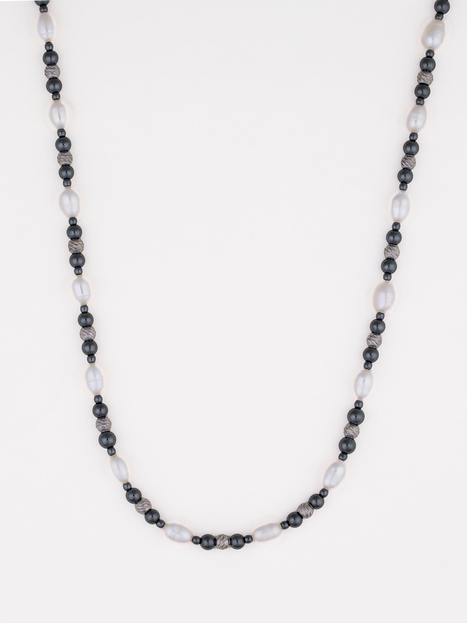 שרשרת Caviar מפנינים לבנות ארוכות וחרוזי המטיט כהים, על רקע לבן בסטודיו.