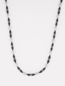 שרשרת Caviar מפנינים לבנות ארוכות וחרוזי המטיט כהים, על רקע לבן בסטודיו.