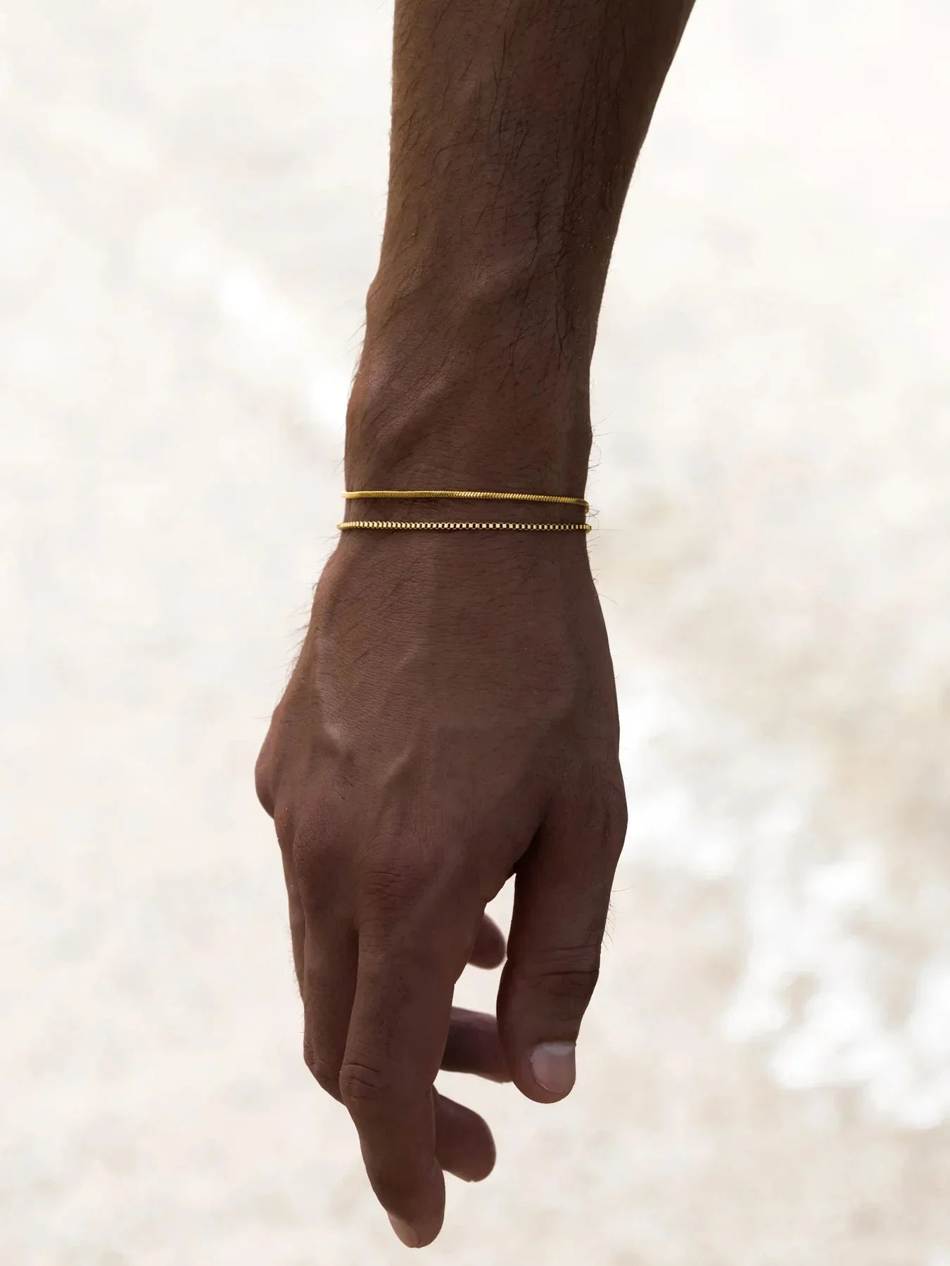 צמיד Manta לגבר בגימור זהב בצילומי לייף סטייל על פרק כף היד