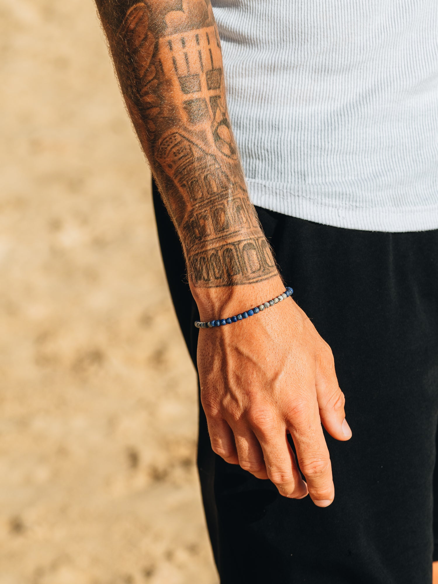 צמיד Marine לגבר משולב עם טבעת וצמיד נוסף, על רקע כחול של האוקיינוס.