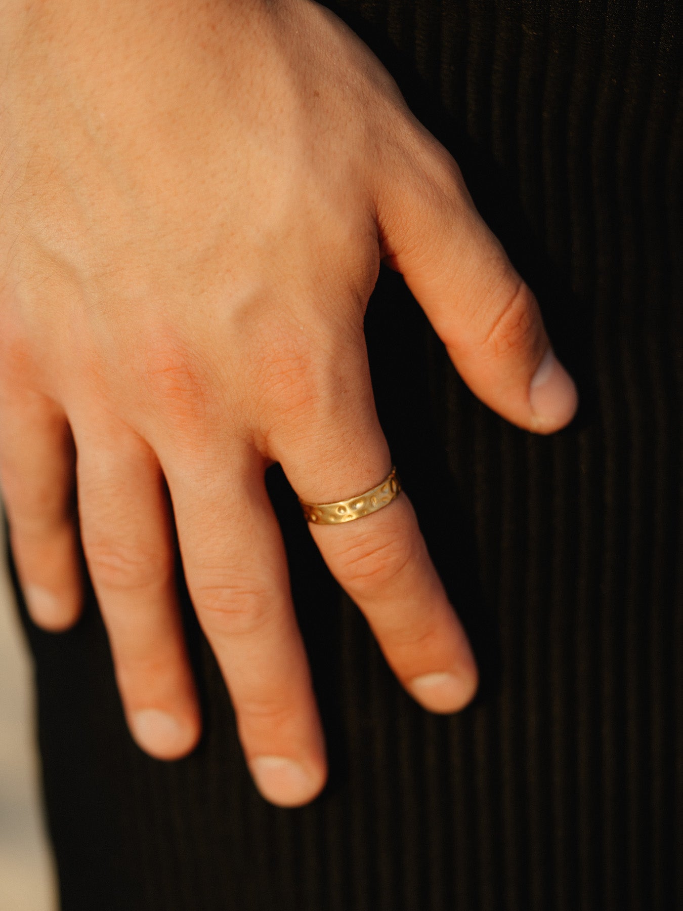 דגם גברי עונד טבעת Meduza זהב בגימור מט, בצילום פורטרט באור רך.