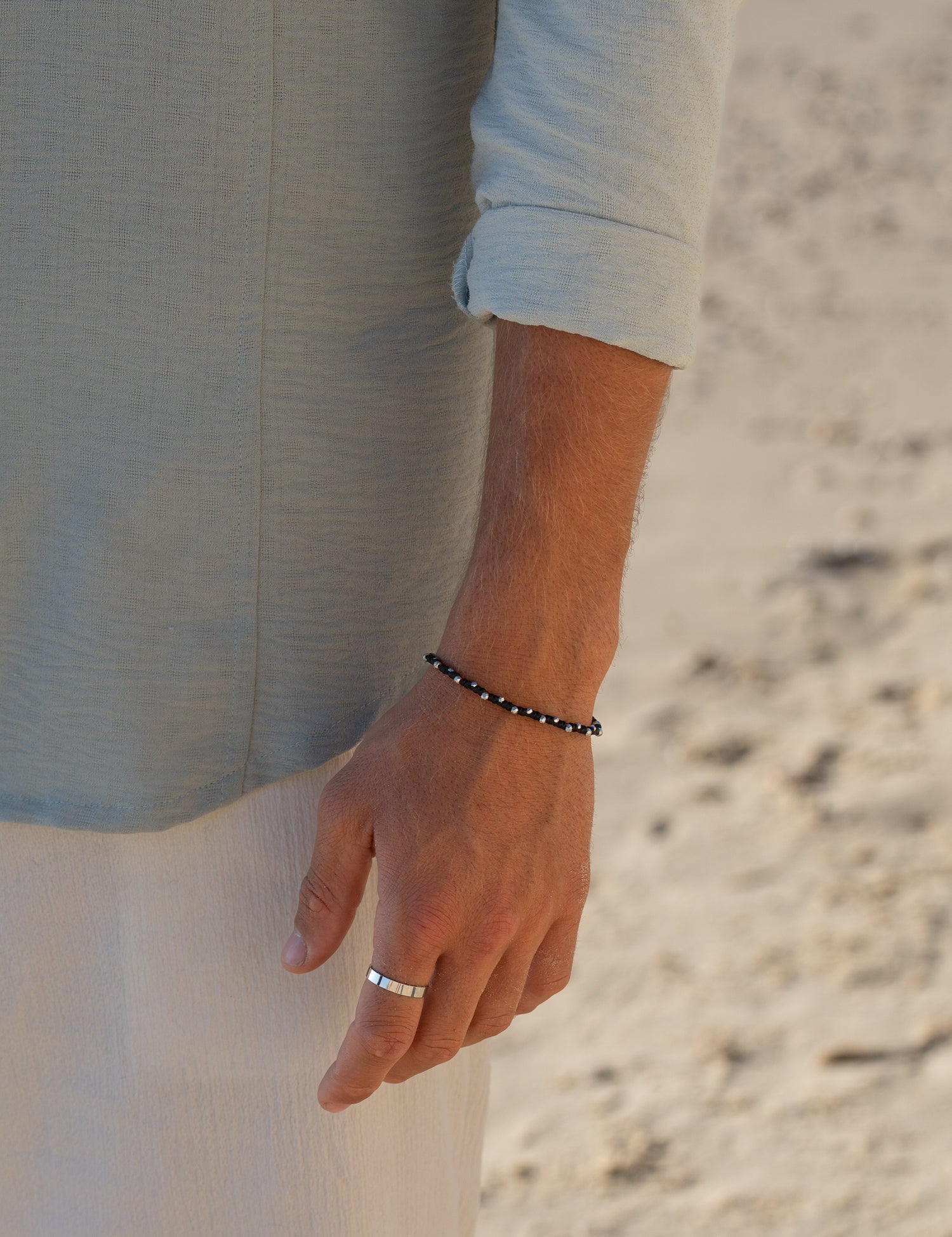 צמיד Moonstone זהב (חוט שעווה) משולב עם צמיד Reef כסף מט (דק), צילום תקריב על בגד בהיר.