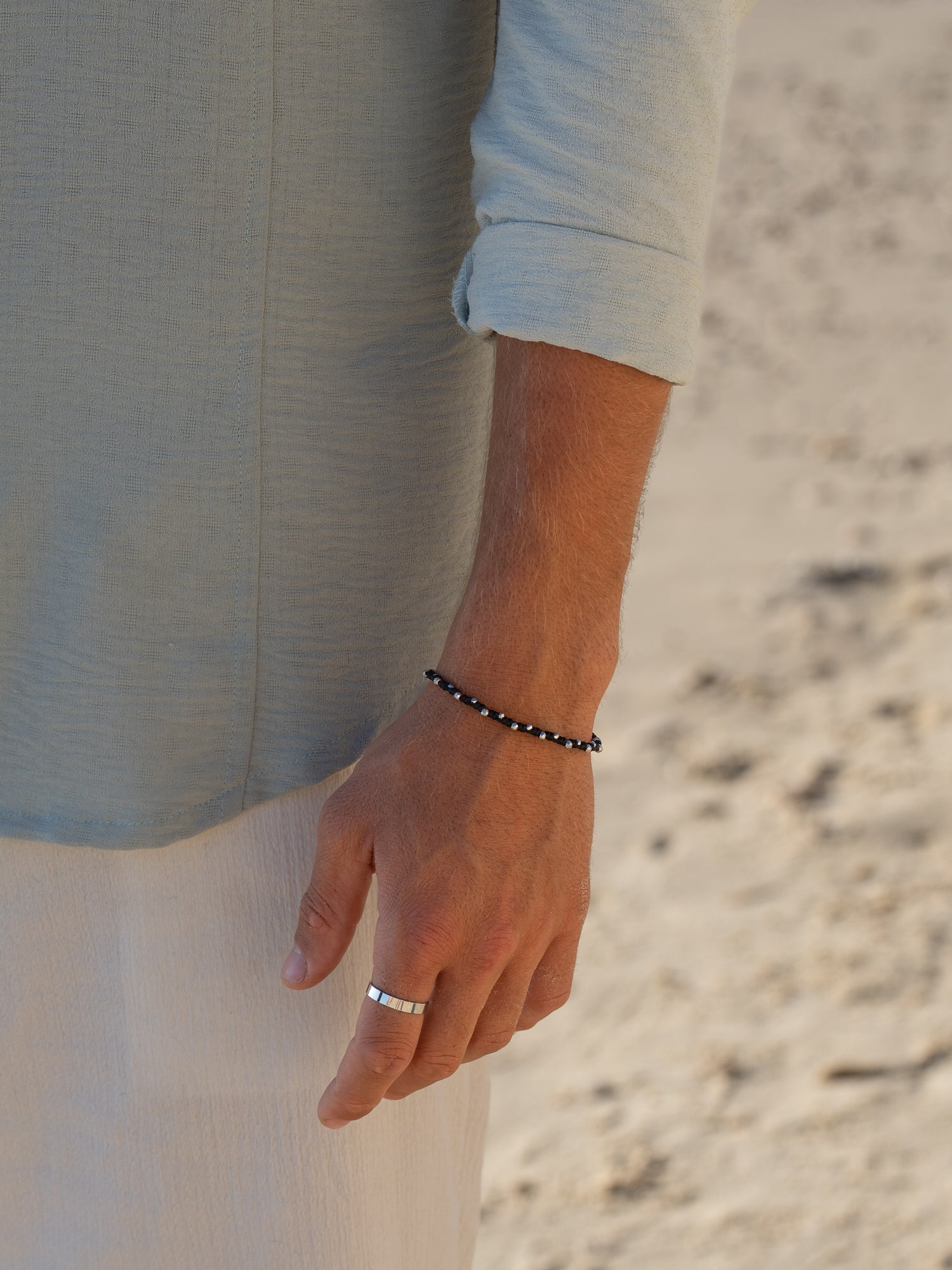 צמיד Moonstone זהב (חוט שעווה) משולב עם צמיד Reef כסף מט (דק), צילום תקריב על בגד בהיר.