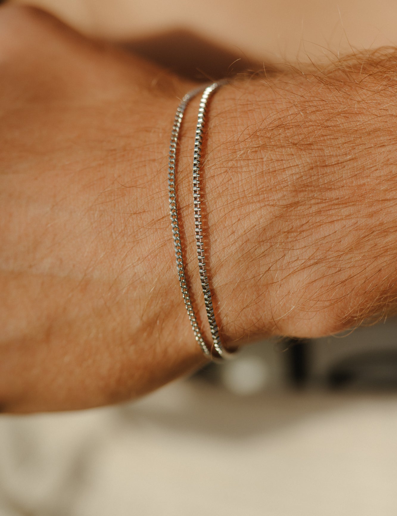 צמד צמידי כסף דקים לגבר מבית NERO: צמיד Octopus (1.4 מ"מ) וצמיד Piranha (1.6 מ"מ) בגימור מבריק עם לוגו מוטבע, למראה מינימליסטי ויומיומי.