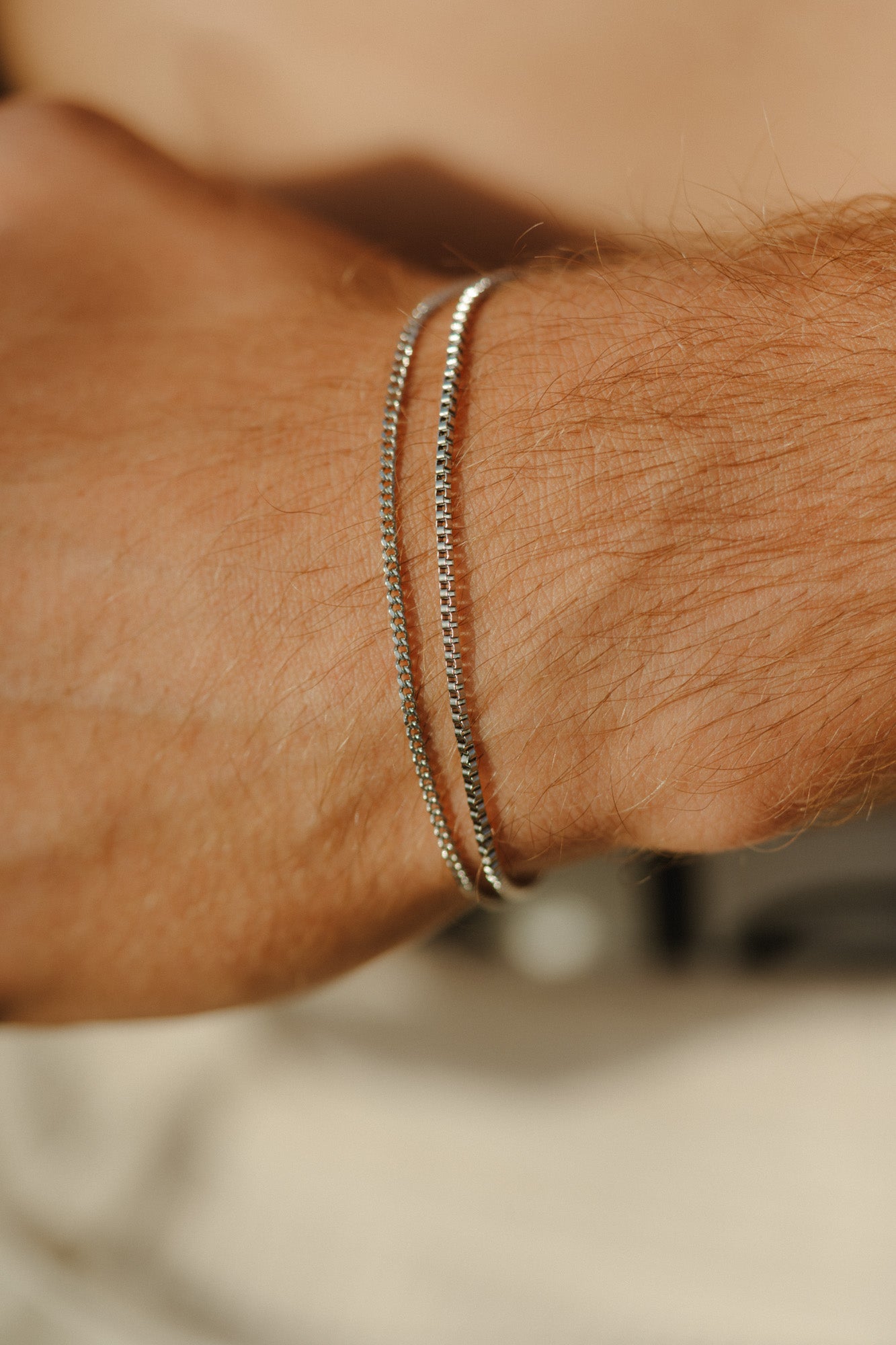 צמד צמידי כסף דקים לגבר מבית NERO: צמיד Octopus (1.4 מ"מ) וצמיד Piranha (1.6 מ"מ) בגימור מבריק עם לוגו מוטבע, למראה מינימליסטי ויומיומי.