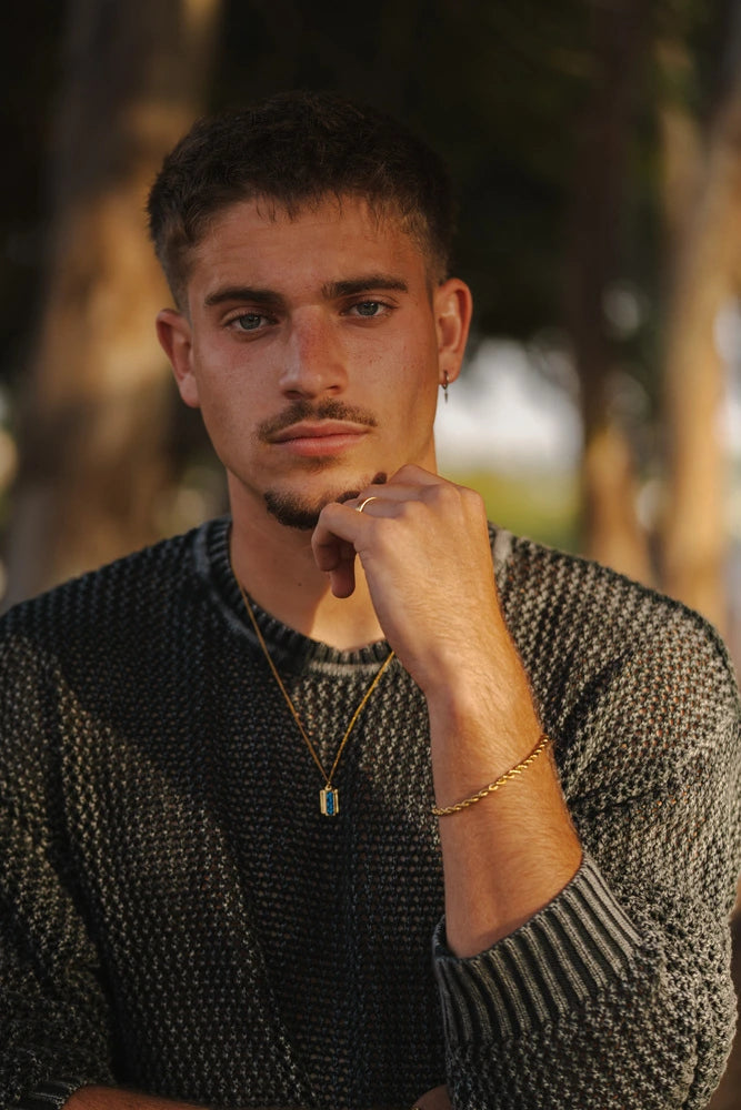 גבר בים עונד צמידי קשיח מכסף, טבעות ושרשרת תליון לגברים מבית נרו NERO - תכשיטים עמידים במים.