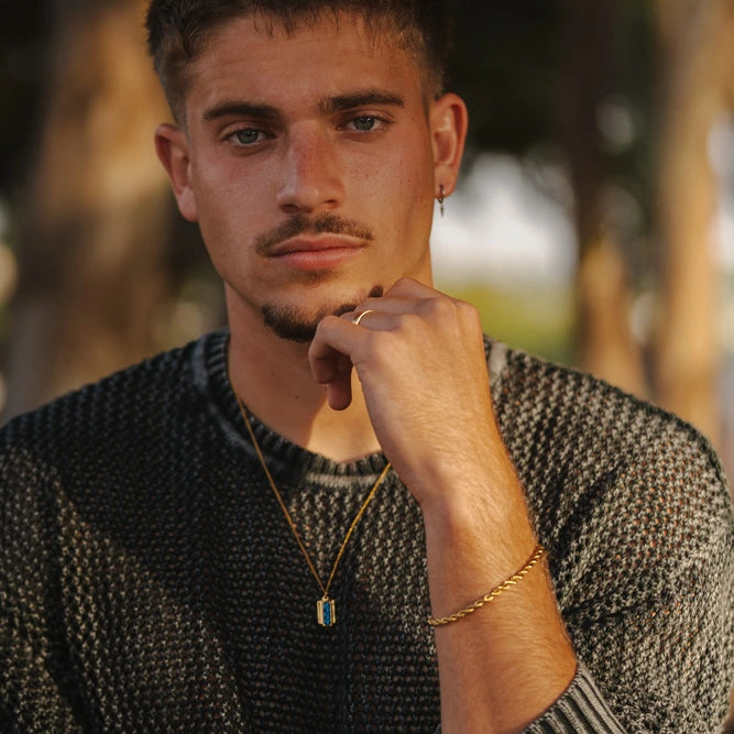 גבר בים עונד צמידי קשיח מכסף, טבעות ושרשרת תליון לגברים מבית נרו NERO - תכשיטים עמידים במים.