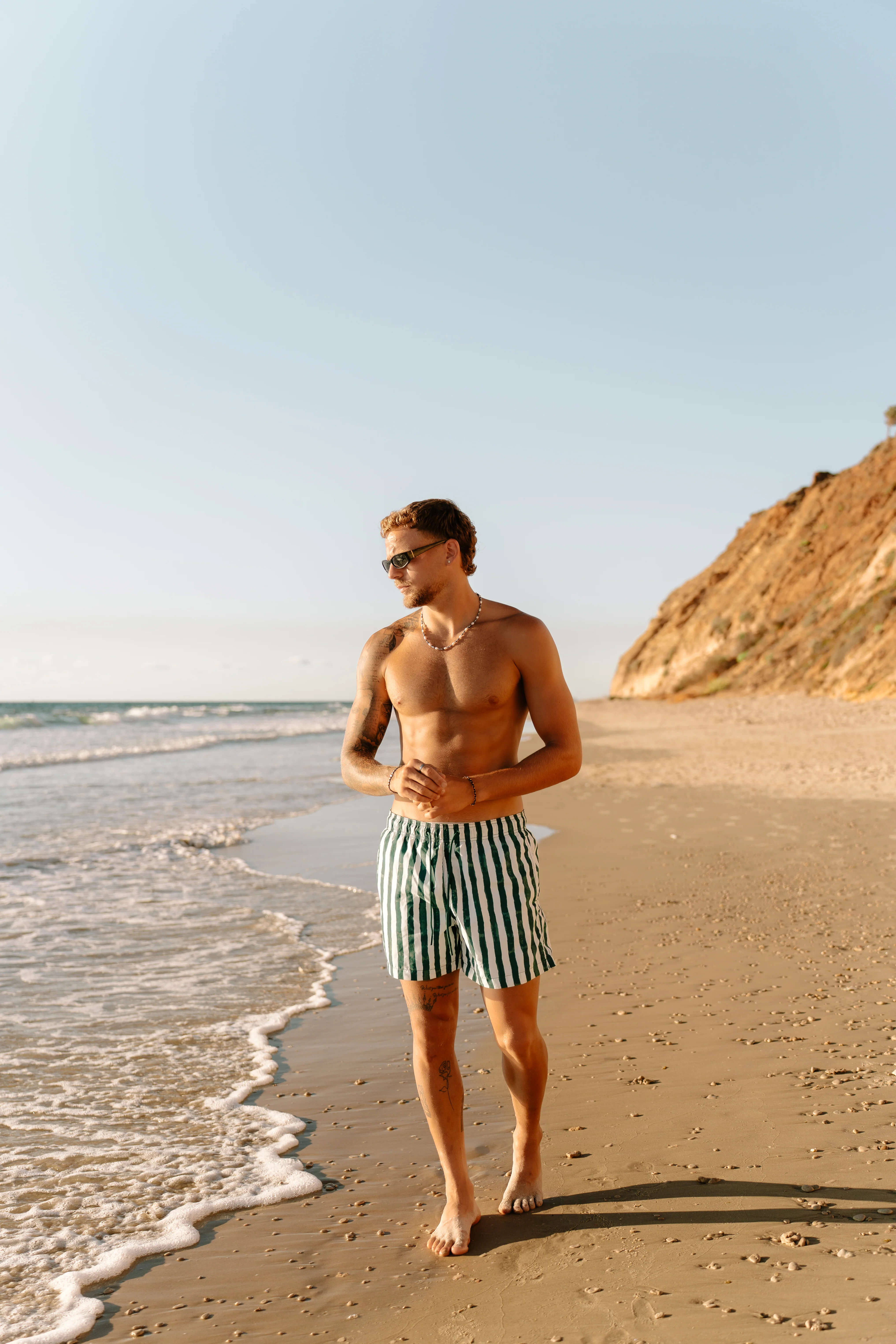 גבר בים עם סט תכשיטי כסף לגברים של נרו NERO - צמידי קשיח וטבעות כסף עמידים במים למראה גברי.