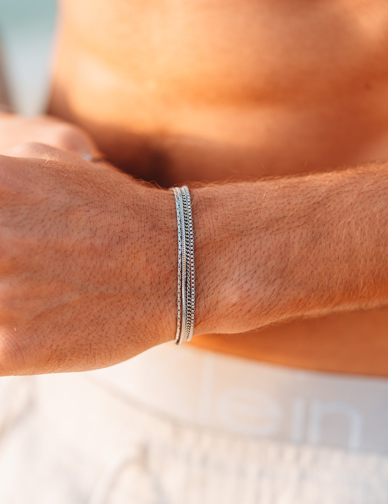 צמיד Octopus כסף של NERO על פרק יד גברי בשמש, סטייל קיץ נקי ומינימליסטי