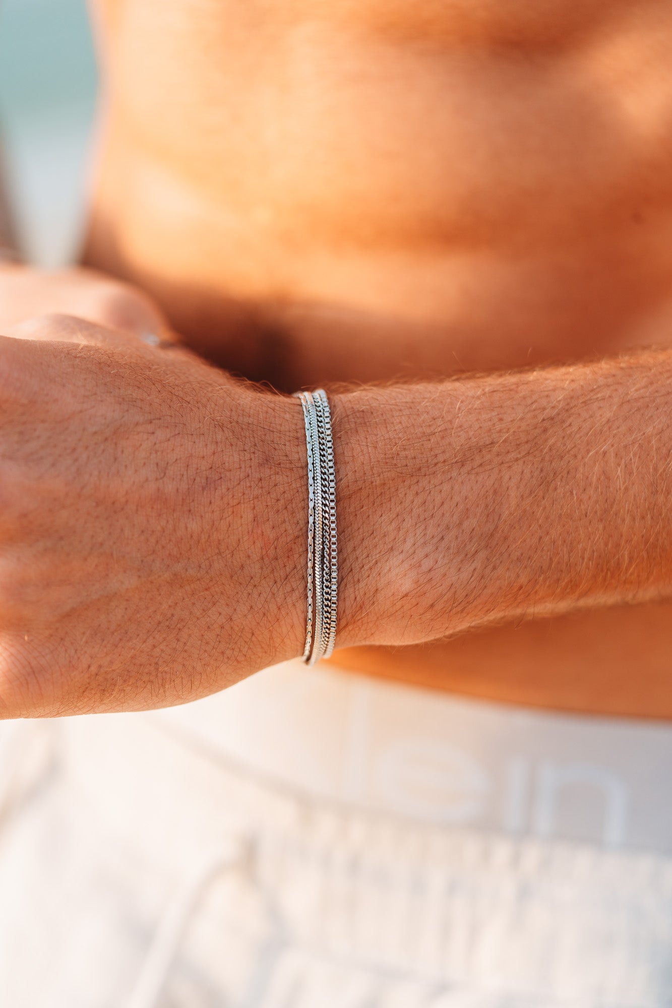 צמיד Octopus כסף של NERO על פרק יד גברי בשמש, סטייל קיץ נקי ומינימליסטי