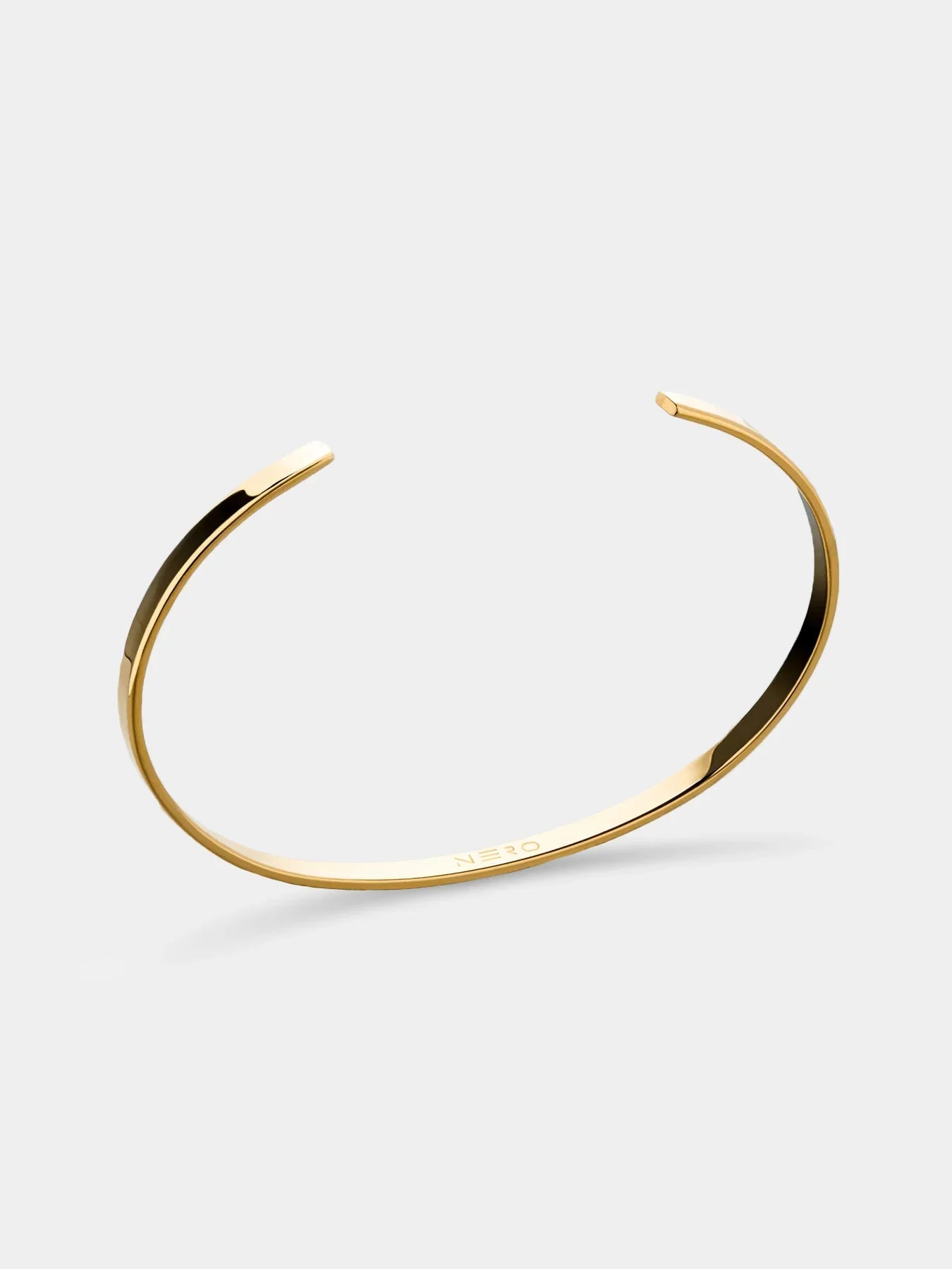צמיד Orca מוזהב בקוטר 3.5 מ״מ על רקע לבן, בעיצוב פתוח עם חריטת NERO פנימית