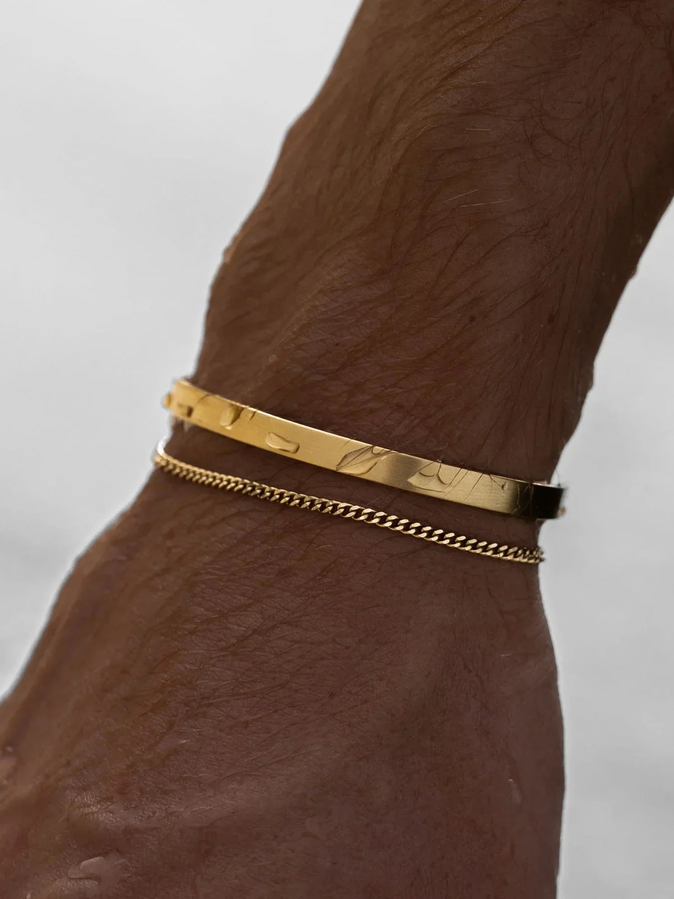 צמיד Piranha לגבר בגימור זהב בשילוב צמיד נוסף בצילומי לייף סטייל