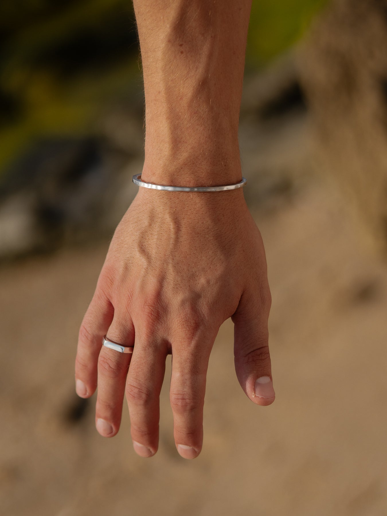 צמיד Reef כסף מט (3.5 מ"מ) על פרק יד גברית, משולב עם טבעת מינימליסטית.