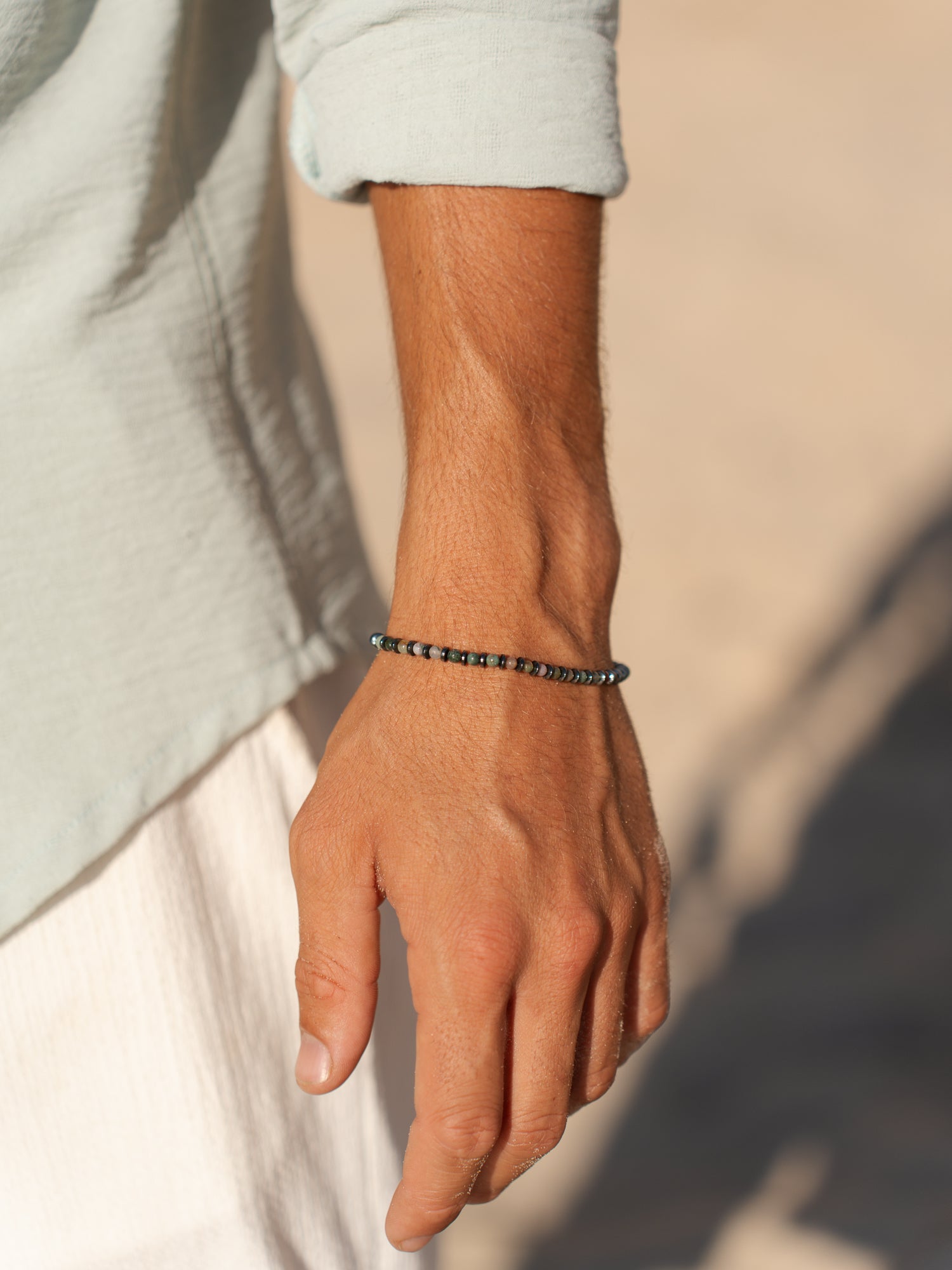 צמיד Tulum על יד גברית, משולב עם שעון וטבעת עדינה בסטייל מינימליסטי.