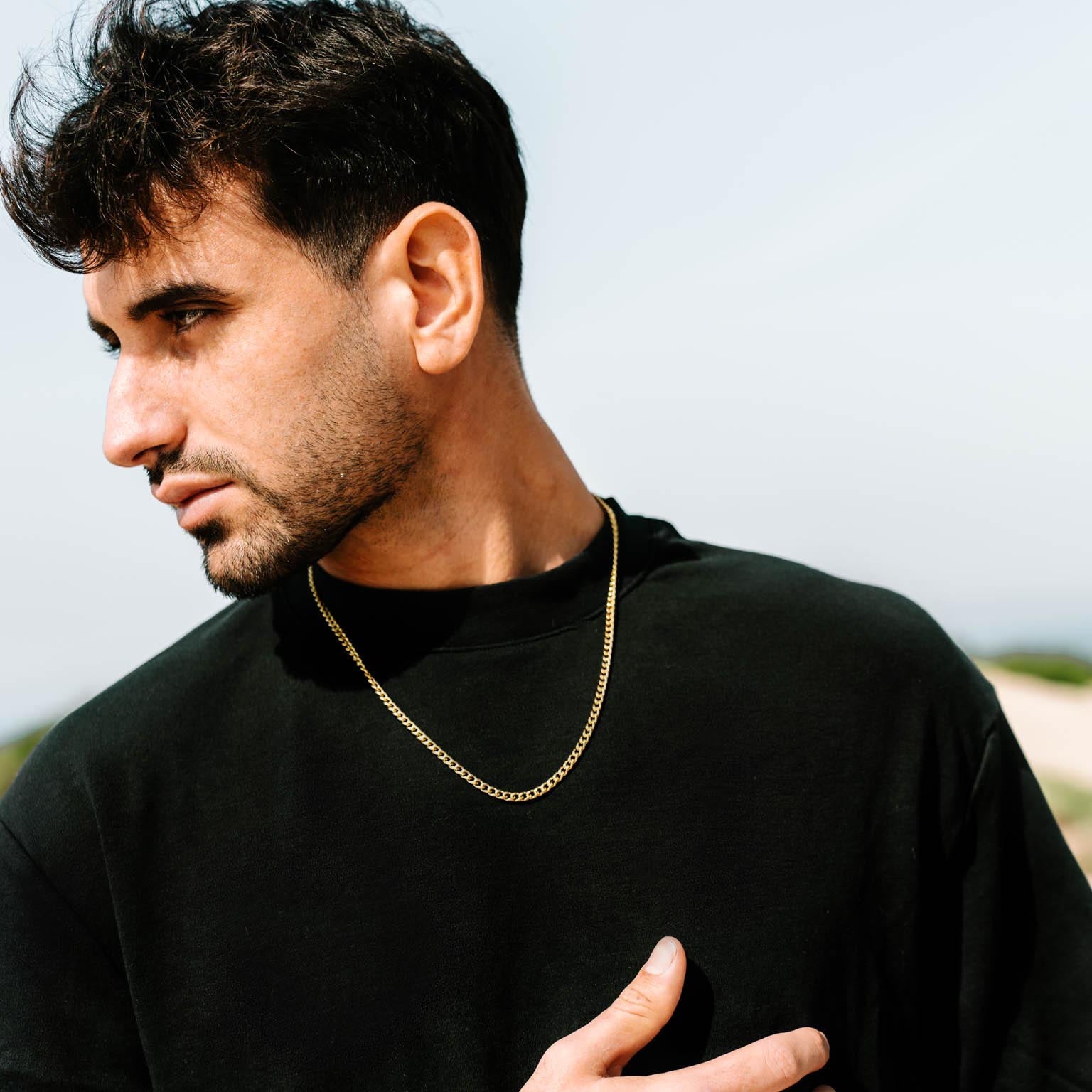 שרשרת Zeus מוזהבת 4 מ״מ על צוואר של דוגמן בחולצת שחור