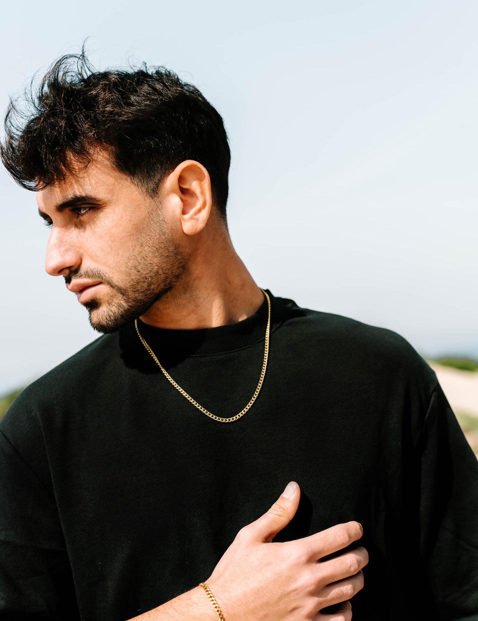 שרשרת Zeus מוזהבת 4 מ״מ על צוואר של דוגמן בחולצת שחור