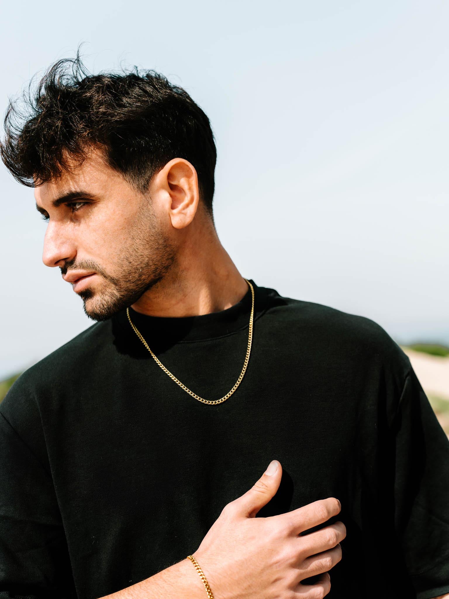 שרשרת Zeus מוזהבת 4 מ״מ על צוואר של דוגמן בחולצת שחור