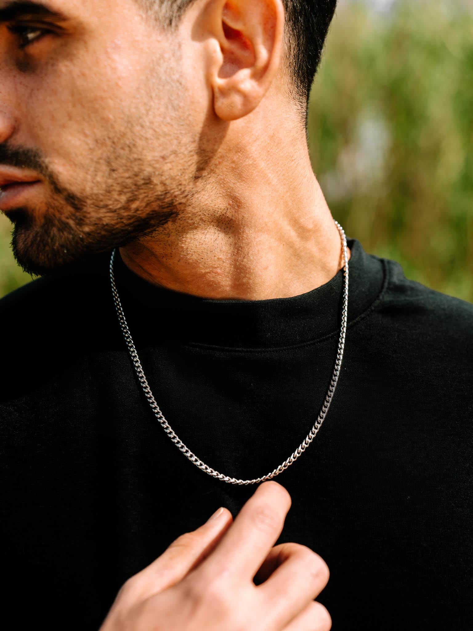 שרשרת Zeus כסופה 4 מ״מ על צוואר של גבר עם חולצת שחור